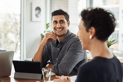 Person smiling at another at a desk